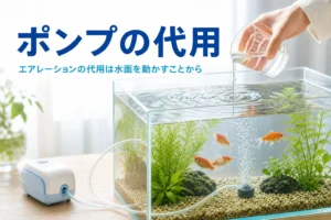 コップで水を落として水面を動かしている水槽と乾電池式のエアーポンプ